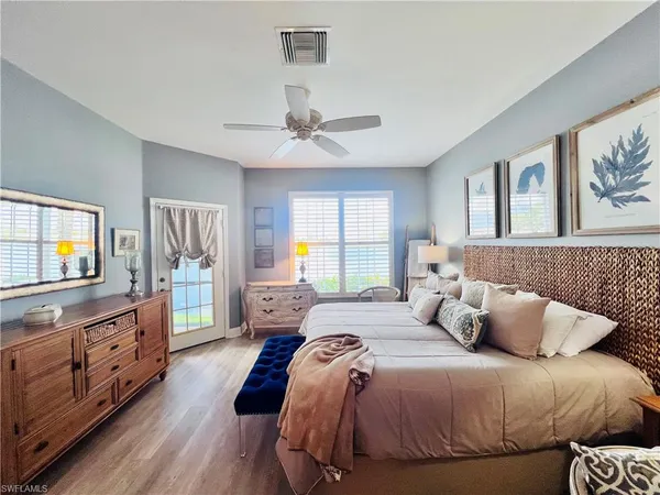 a bedroom with a large bed and a flat tv screen on dresser