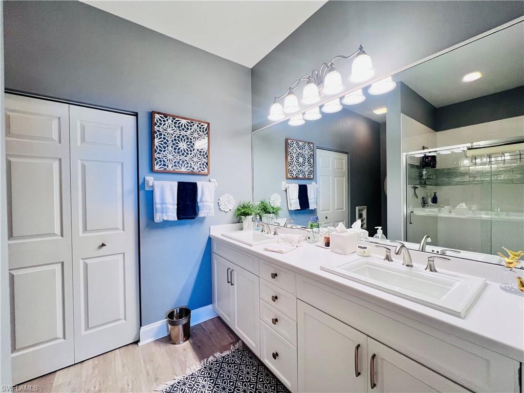 3250 West Crown Pointe Boulevard, Unit 101 Naples, FL 34112 - Photo 16 of 46 a bathroom with a sink vanity and a mirror