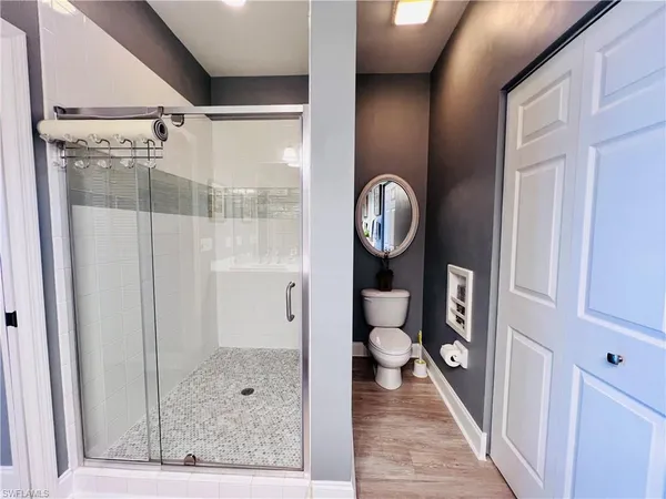 a bathroom with a shower and mirror