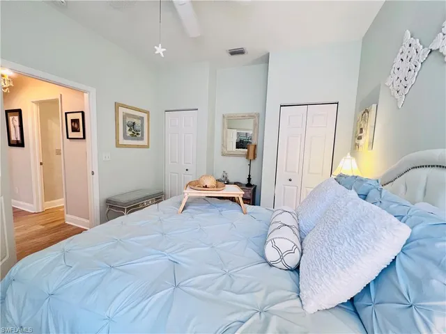 a bedroom with a bed and dresser with wooden floor