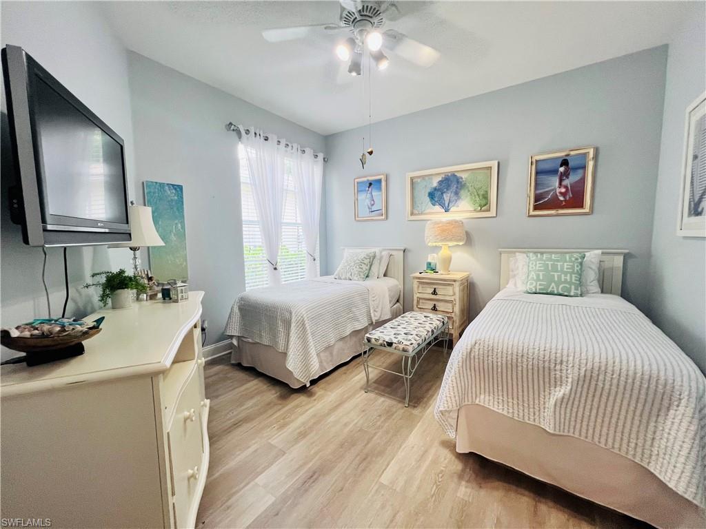 3250 West Crown Pointe Boulevard, Unit 101 Naples, FL 34112 - Photo 21 of 46 a bedroom with a bed a couch and a flat tv screen on dresser