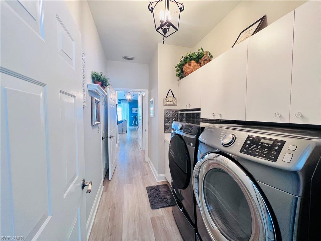 3250 West Crown Pointe Boulevard, Unit 101 Naples, FL 34112 - Photo 24 of 46 a view of washer and dryer with bathroom in the background