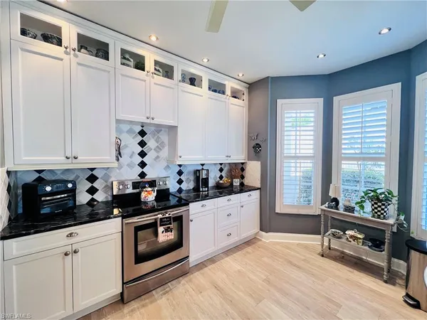 a kitchen with stainless steel appliances a stove a sink and white cabinets