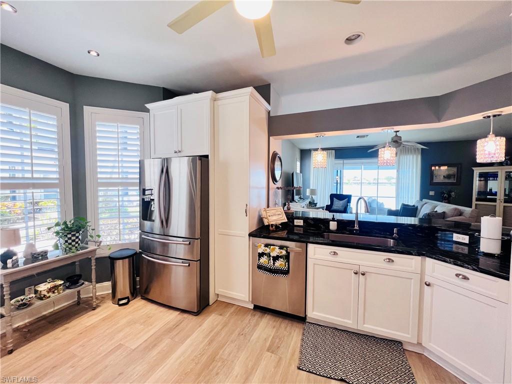 3250 West Crown Pointe Boulevard, Unit 101 Naples, FL 34112 - Photo 5 of 46 a kitchen with granite countertop a refrigerator a sink a stove and cabinets
