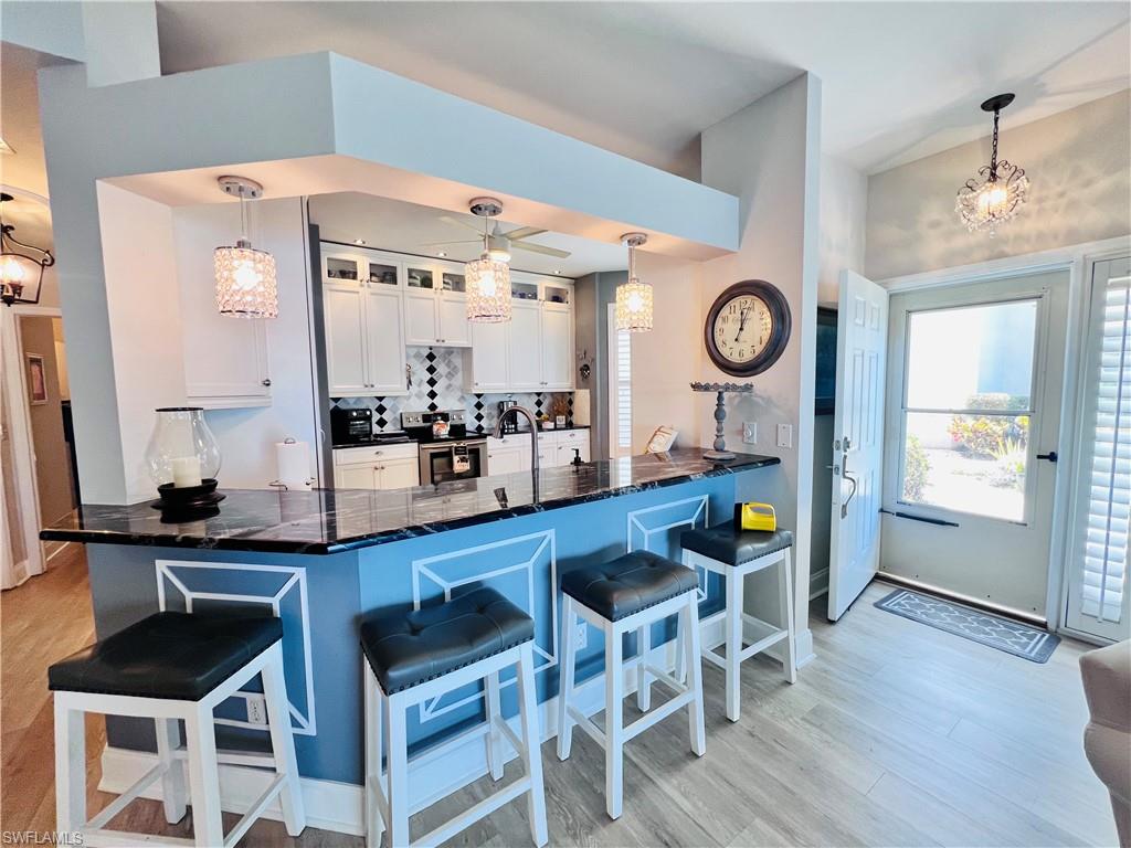 3250 West Crown Pointe Boulevard, Unit 101 Naples, FL 34112 - Photo 6 of 46 a kitchen with a dining table and chairs