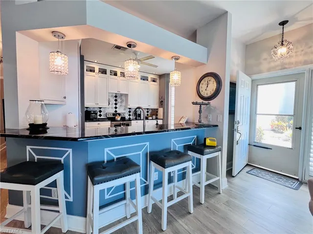 a kitchen with stainless steel appliances a table chairs and a large window
