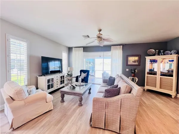 a living room with furniture flat screen tv and a large window