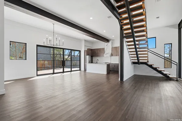 a view of a big room with wooden floor and a kitchen