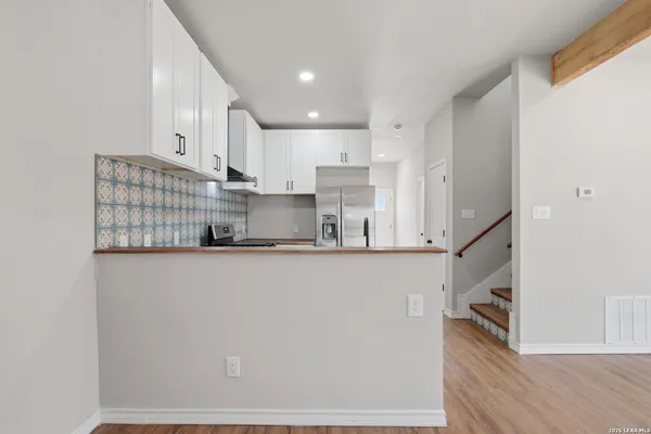 a kitchen with cabinets stainless steel appliances and wooden floor