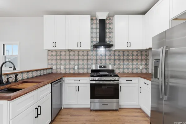 a kitchen with stainless steel appliances a stove sink and cabinets