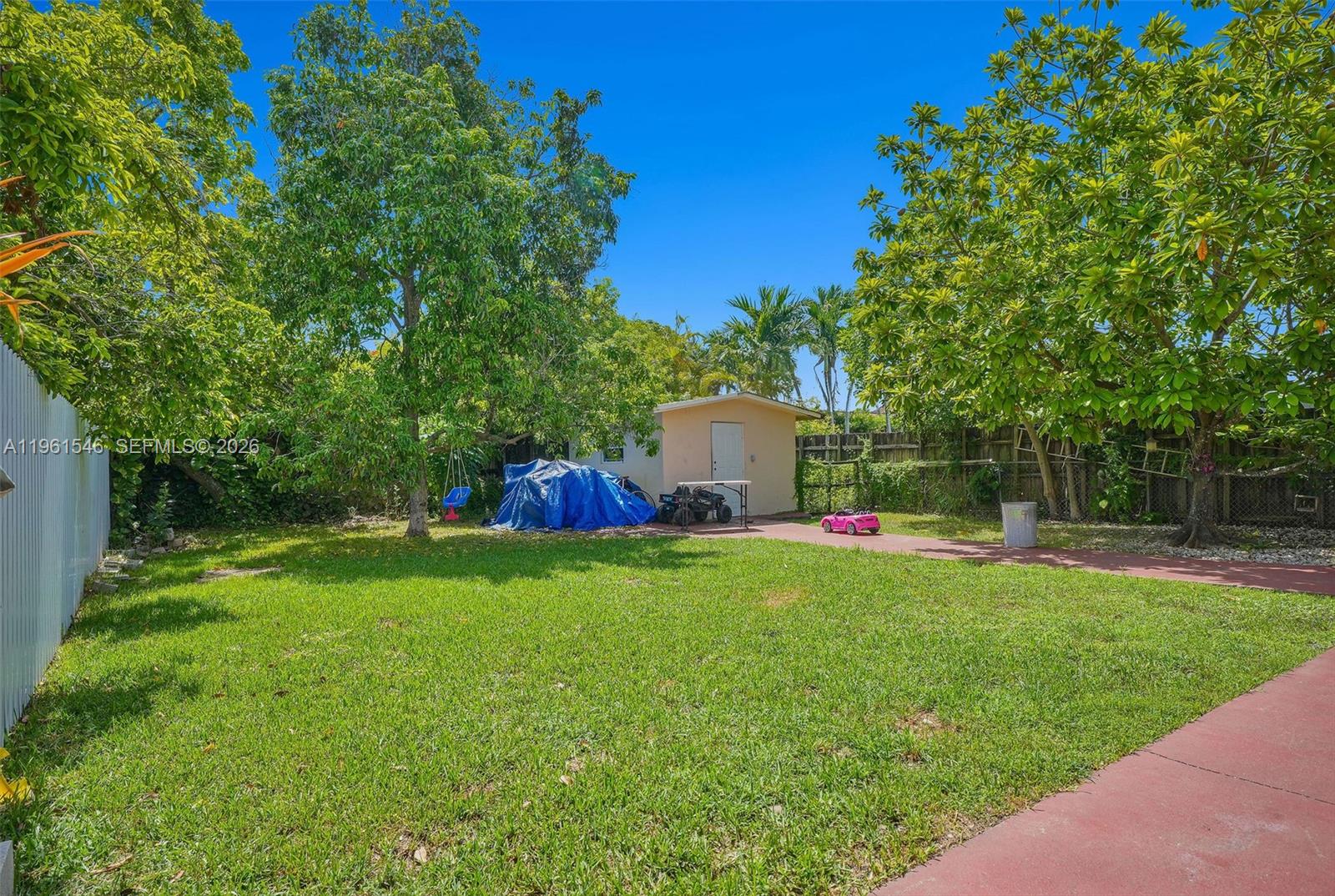 2821 Southwest 65th Avenue Miami, FL 33155 - Photo 11 of 14 a backyard of a house with table and chairs plants and large tree