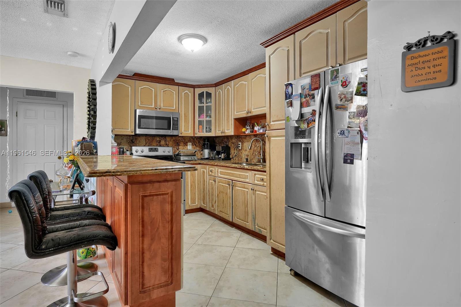 2821 Southwest 65th Avenue Miami, FL 33155 - Photo 4 of 14 a kitchen with stainless steel appliances granite countertop a refrigerator sink and cabinets