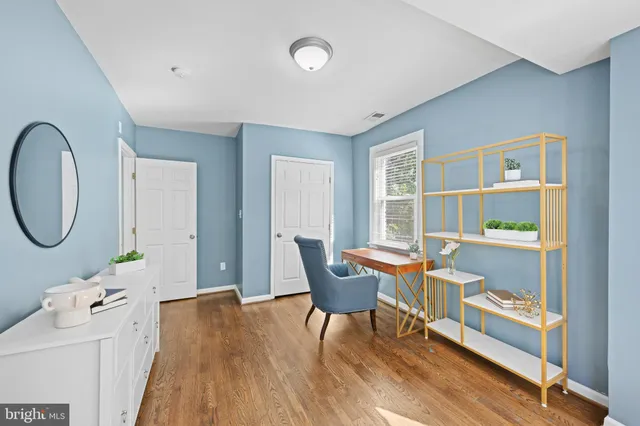 a living room with furniture a window and wooden floor