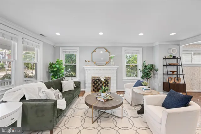 a living room with furniture a fireplace and a large window