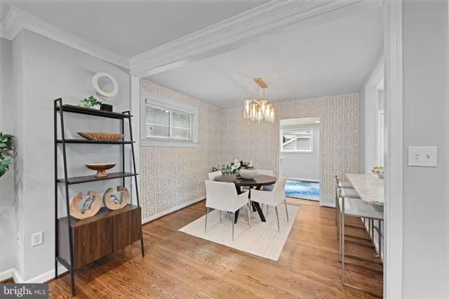 a view of a dining room with furniture a chandelier and wooden floor