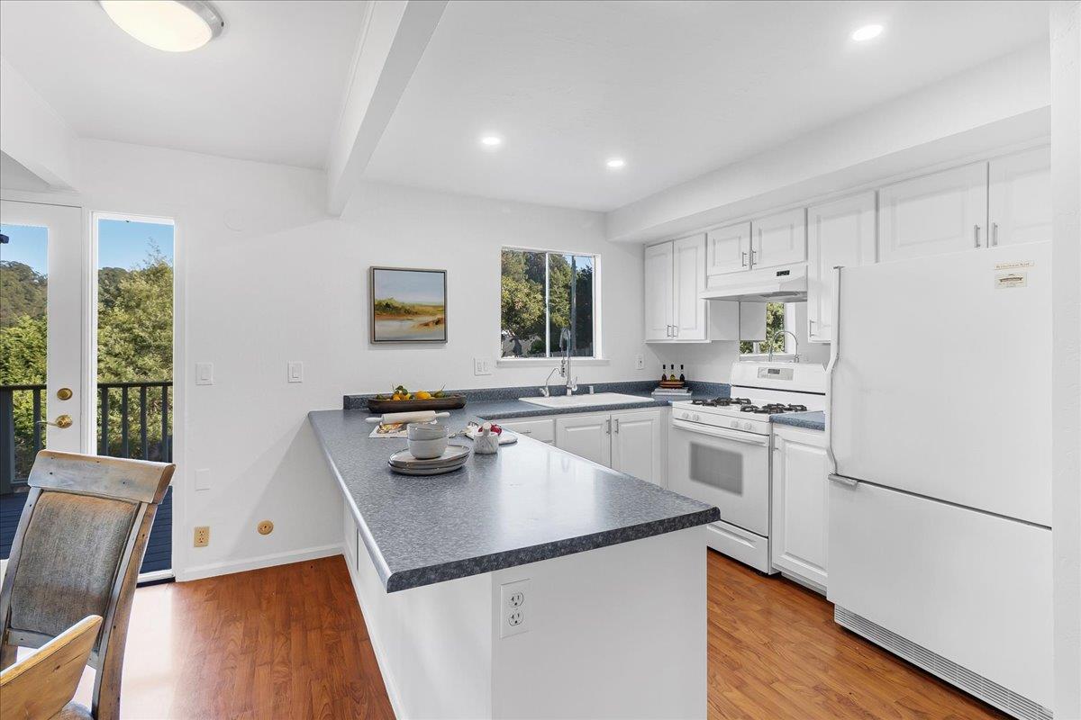 3560 Viola Drive Aromas, CA 95004 - Photo 15 of 42 a kitchen with a sink a stove a refrigerator and white cabinets