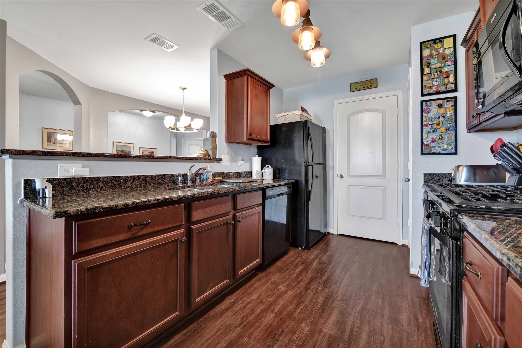 1827 Garnet Breeze Drive Rosharon, TX 77583 - Photo 11 of 23 a kitchen with stainless steel appliances granite countertop a stove cabinets and wooden floor