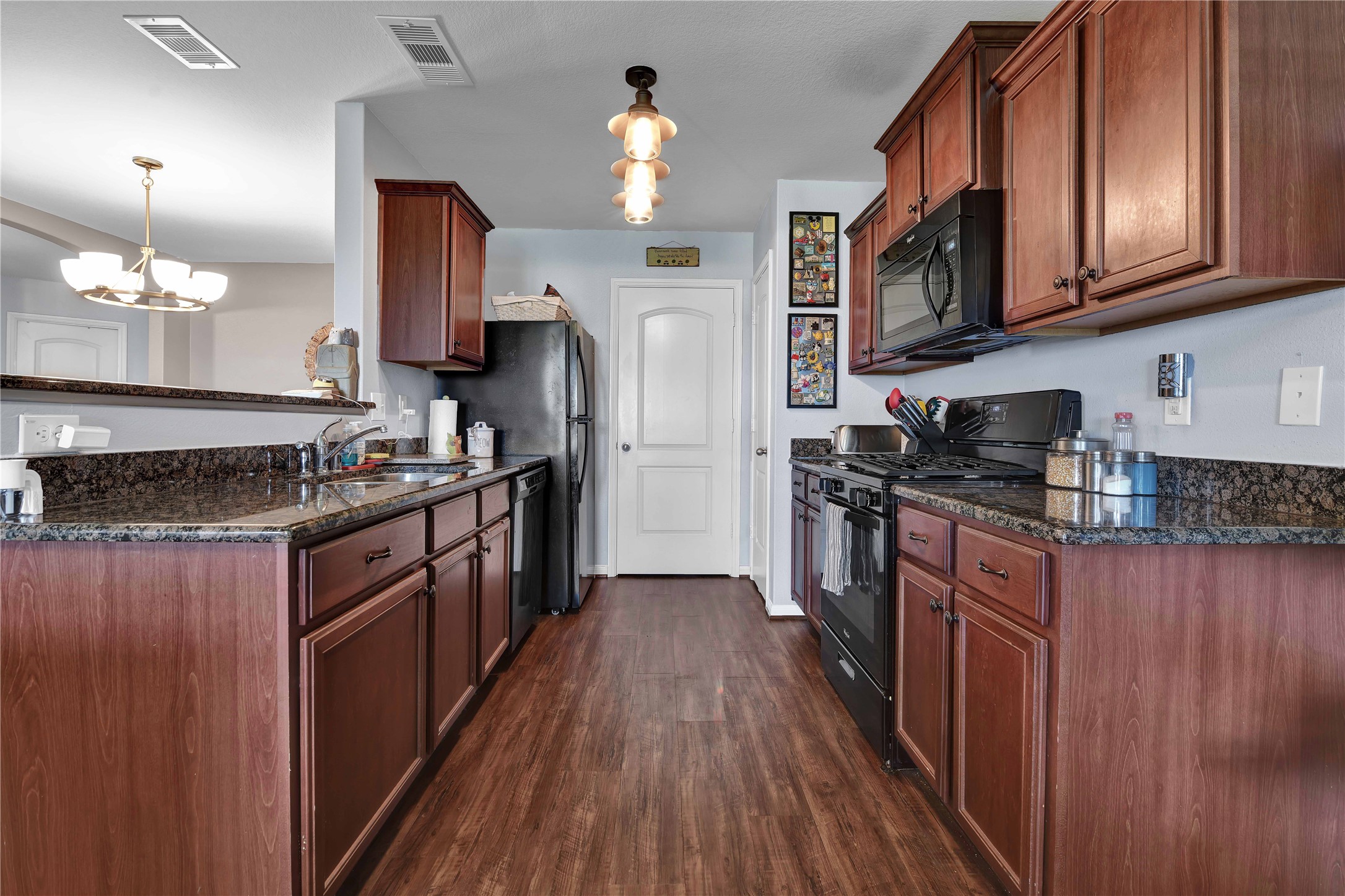 1827 Garnet Breeze Drive Rosharon, TX 77583 - Photo 10 of 23 a kitchen with stainless steel appliances granite countertop a stove a sink dishwasher a refrigerator and a stove with wooden floor