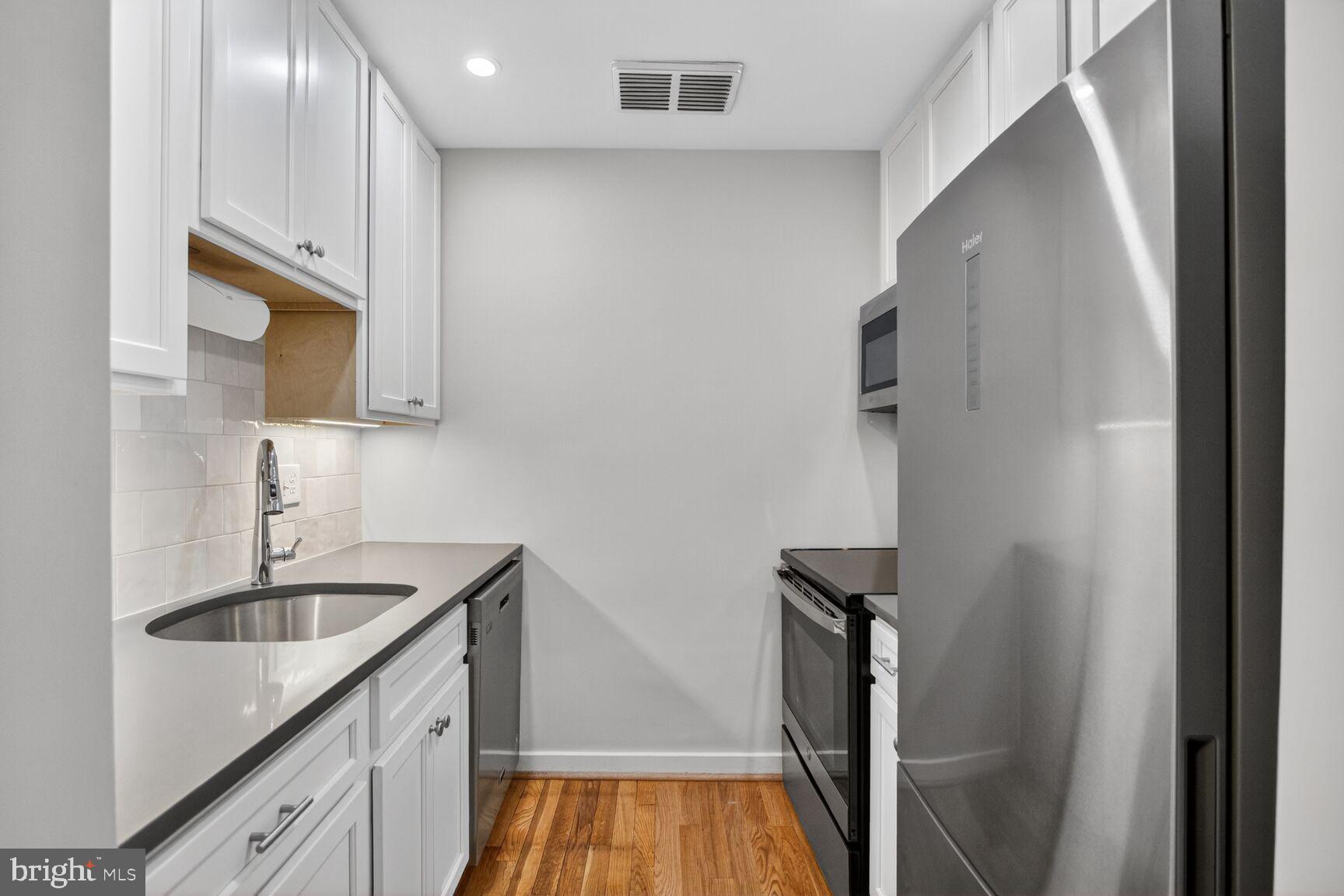 8205 Grubb Road, Unit G202 Silver Spring, MD 20910 - Photo 13 of 38 a kitchen with sink a microwave and cabinets