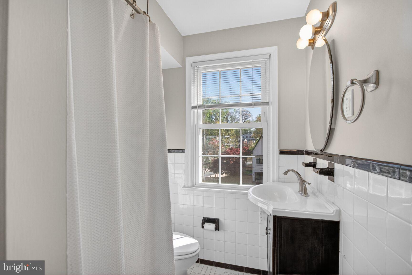 8205 Grubb Road, Unit G202 Silver Spring, MD 20910 - Photo 14 of 38 a bathroom with a sink a toilet and a window