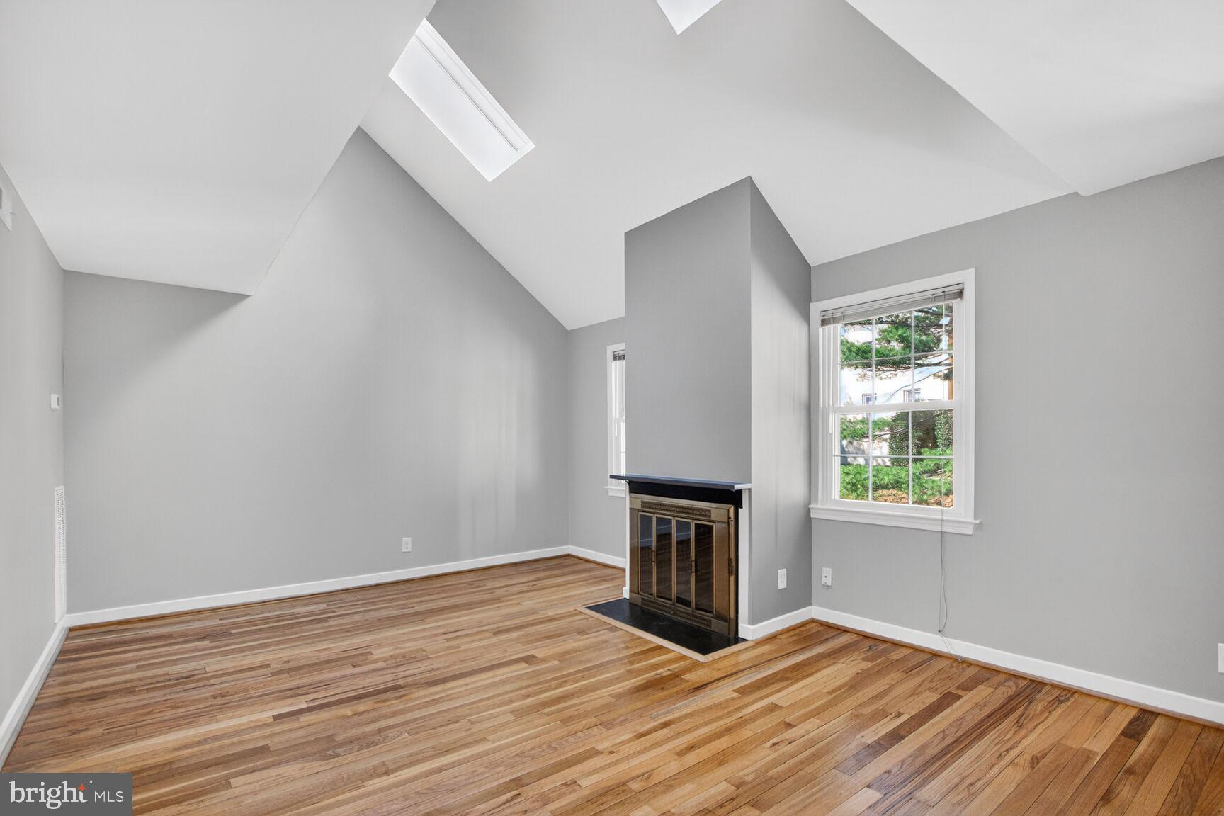 8205 Grubb Road, Unit G202 Silver Spring, MD 20910 - Photo 7 of 38 an empty room with wooden floor fireplace and windows
