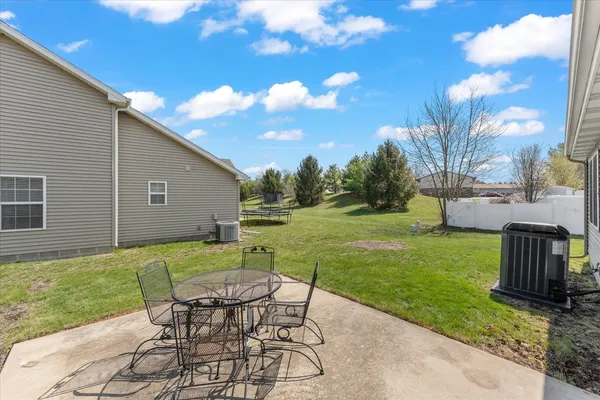 a view of a backyard with table and chairs with wooden fence