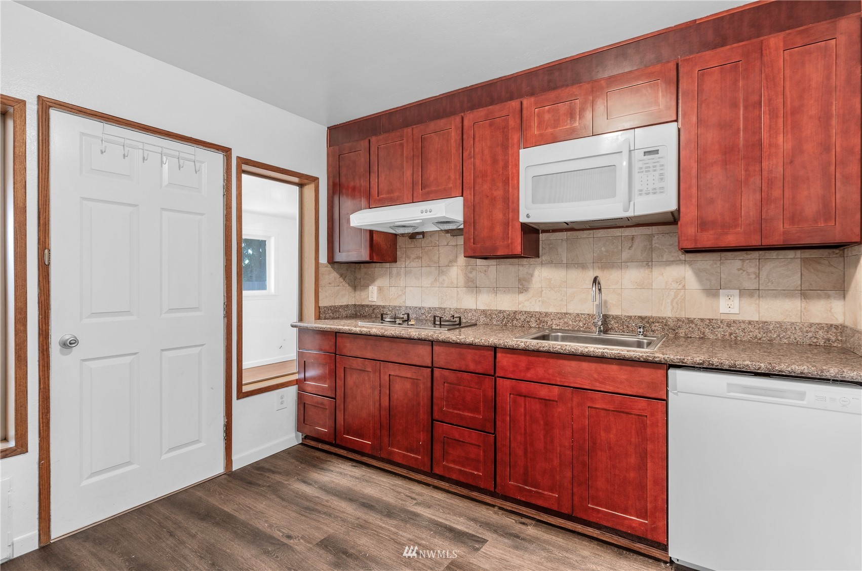 2115 Northeast 8th Street Renton, WA 98056 - Photo 12 of 19 a kitchen with granite countertop wooden cabinets a sink and a window