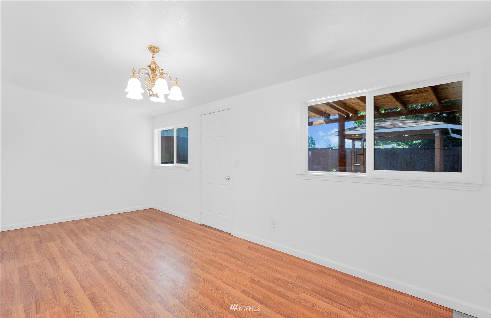 2115 Northeast 8th Street Renton, WA 98056 - Photo 18 of 19 a view of empty room with wooden floor and chandelier