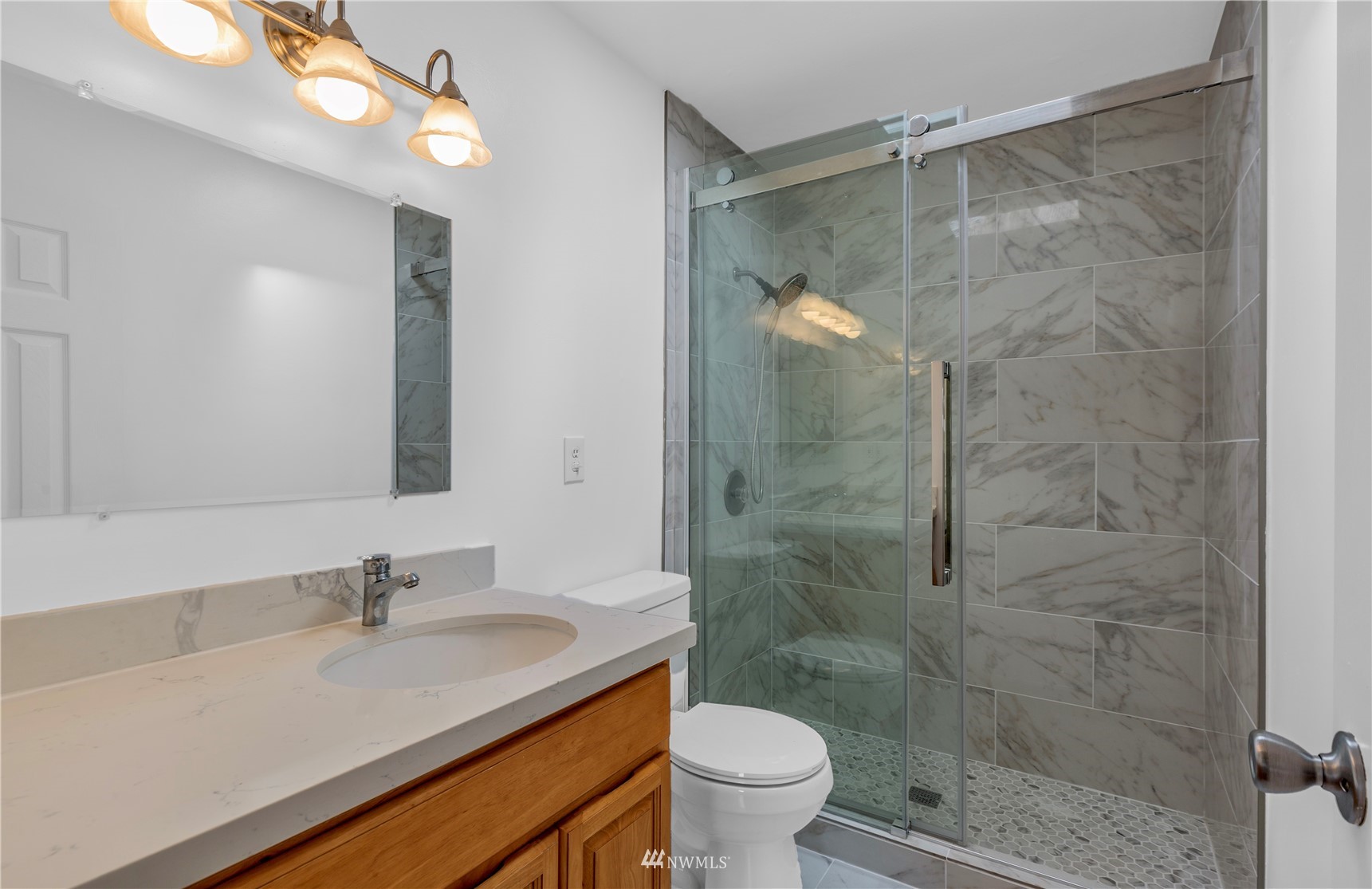2115 Northeast 8th Street Renton, WA 98056 - Photo 6 of 19 a bathroom with a shower sink vanity mirror and toilet