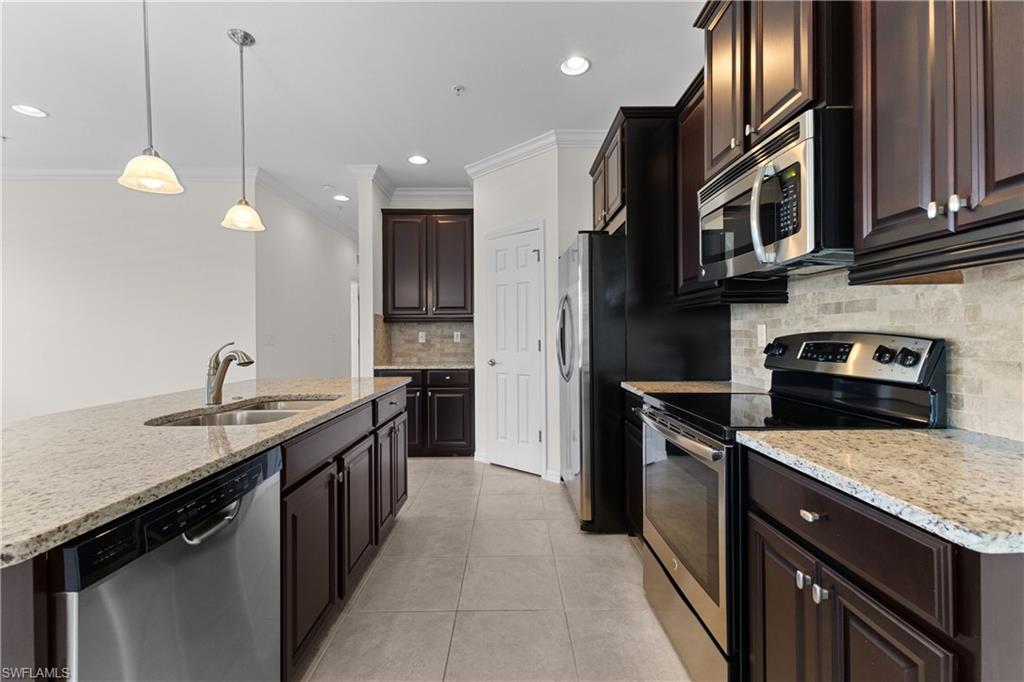 8531 Violeta Street, Unit 203 Estero, FL 34135 - Photo 9 of 35 a kitchen with stainless steel appliances granite countertop a sink a stove and a refrigerator