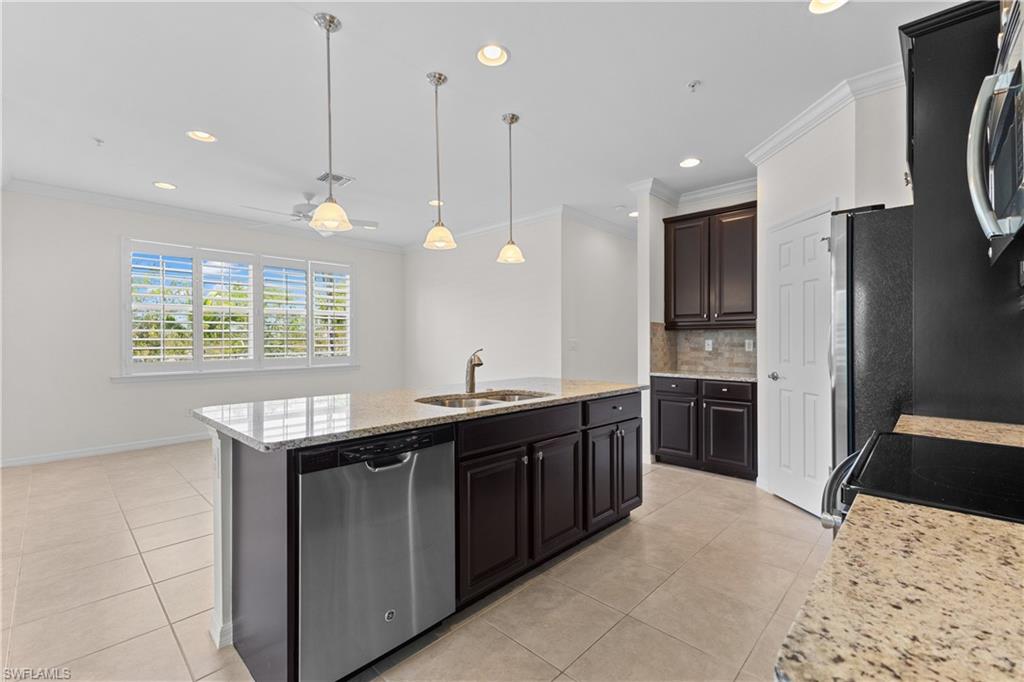 8531 Violeta Street, Unit 203 Estero, FL 34135 - Photo 10 of 35 a kitchen with stainless steel appliances granite countertop a sink a stove and a refrigerator