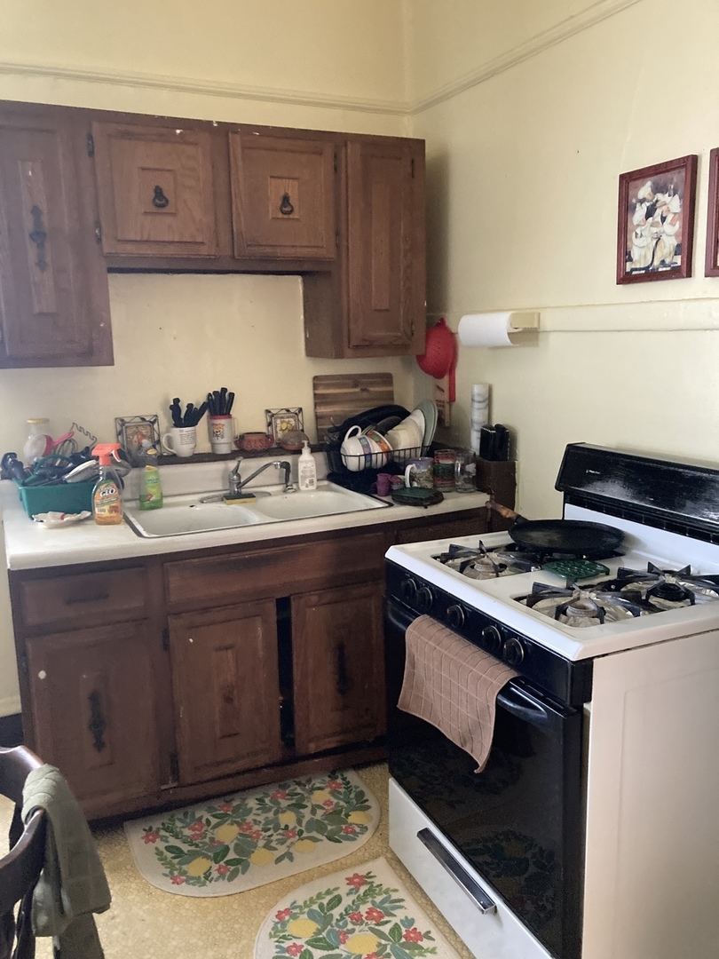 910 West 32nd Place Chicago, IL 60608 - Photo 20 of 28 a kitchen with a stove and wooden cabinets