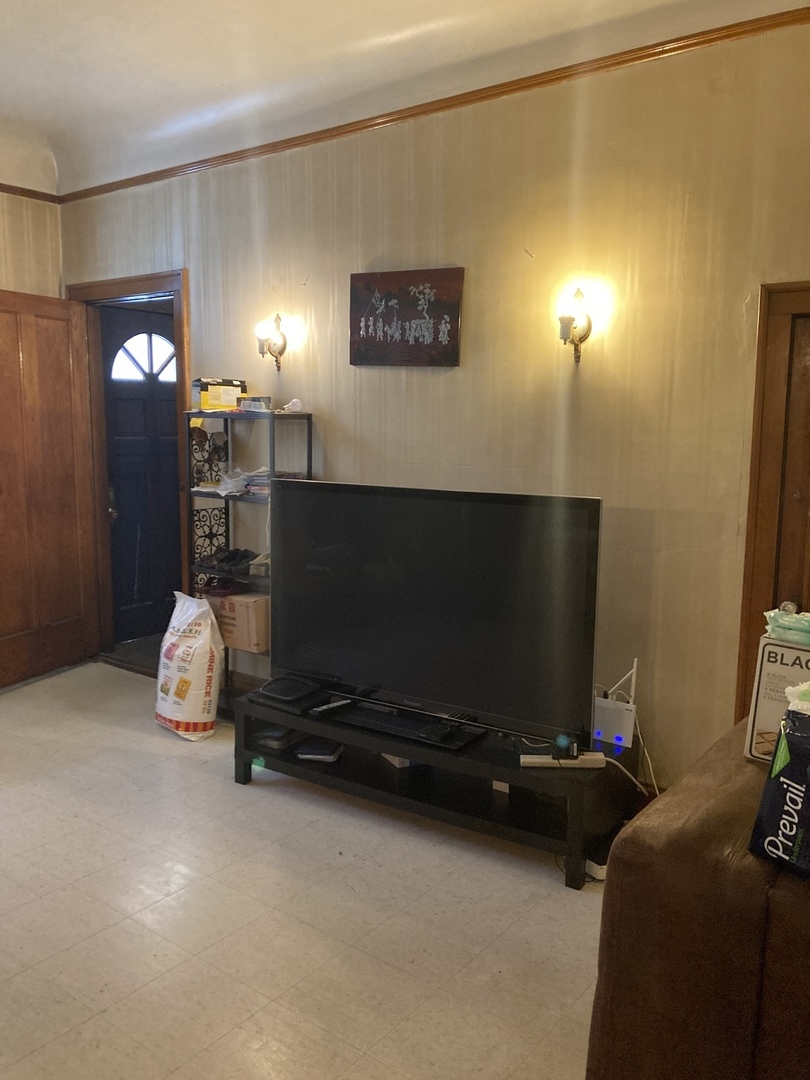 910 West 32nd Place Chicago, IL 60608 - Photo 7 of 28 a living room with furniture gym equipment and a flat screen tv