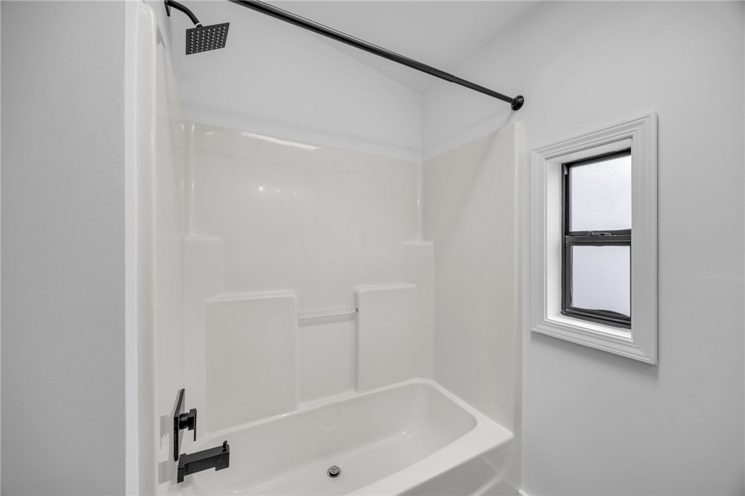 1230 Melton Road, Unit 30 West Union, SC 29696 - Photo 23 of 42 A pristine shower-tub combination features a modern rain showerhead and dark fixtures, complemented by a window providing natural light.
