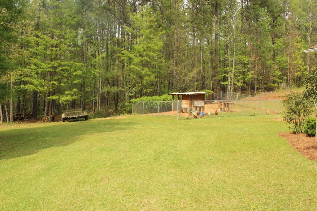 375 Old Cabaniss Road Forsyth, GA 31029 - Photo 22 of 23 a view of a swimming pool with a bench and trees in the background