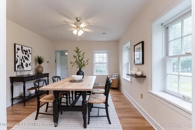 a view of a dining room and livingroom with furniture wooden floor a rug a potted plant and a chandelier