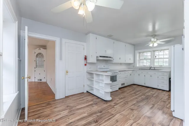 a kitchen with wooden floors and white cabinets