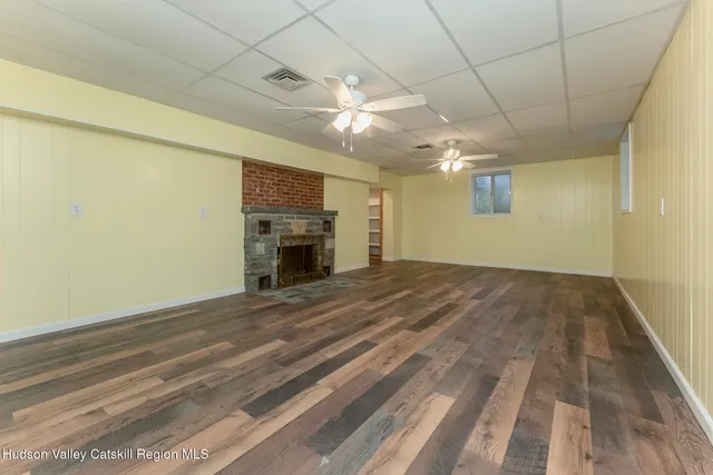 a view of empty room with a fireplace and wooden floor