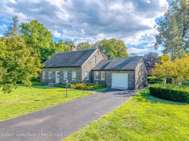 a view of a house with a big yard plants and large trees