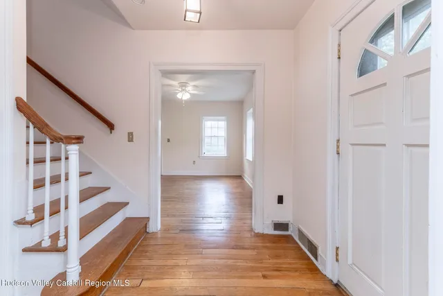 a view of entryway with wooden floor and stairs