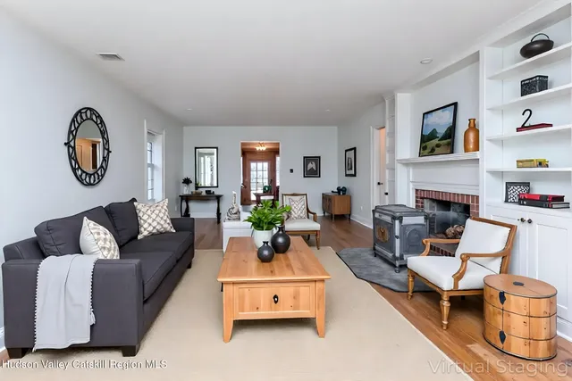 a living room with furniture a fireplace and a window