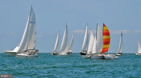 an aerial view of a city with lots of residential buildings ocean and mountain view in back