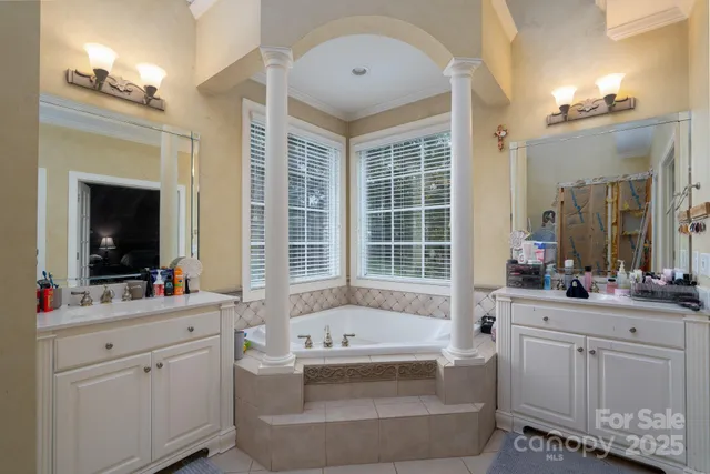 a bathroom with a tub sink and mirror
