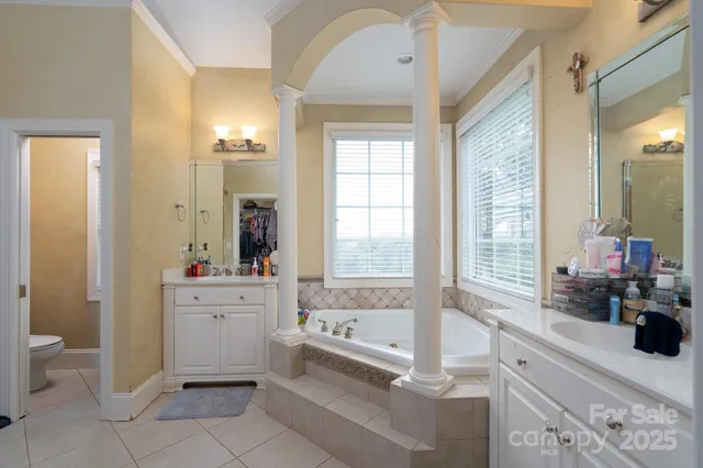 a spacious bathroom with a tub sink and mirror
