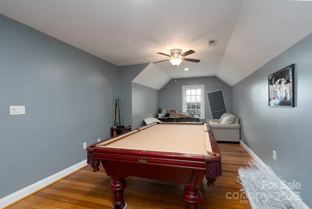 a room with pool table and wooden floor