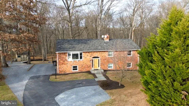 an aerial view of a house with yard and trees