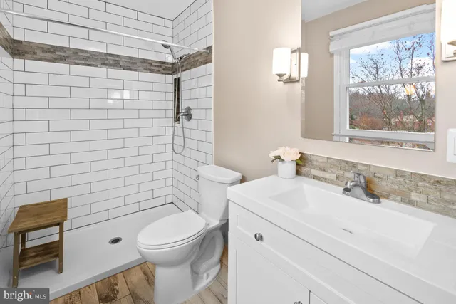 a bathroom with a toilet a sink a mirror and a shower