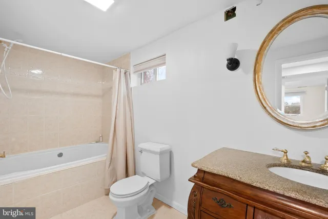 a bathroom with a granite countertop sink a toilet and a mirror