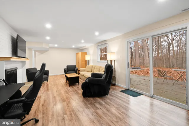 a living room with furniture a fireplace and a floor to ceiling window
