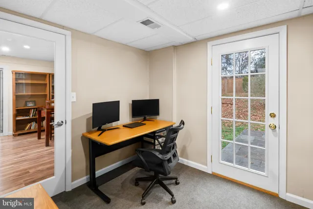 a view of a workspace with furniture and a window